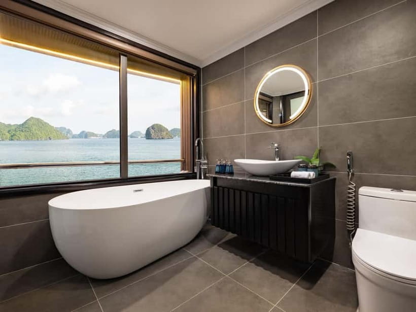 2-Day or 3-Day: Halong&Lan Ha Bay Cruise 5<em> balcony,bathtub – What to know before booking’ /></p>
<ul>
<li><strong>Two nights add the village visit:</strong> Only the 3-day option includes Viet Hai, reached by transfer boat and explored by bicycle or electric car.</li>
<li><strong>The cabin is a major part of the value:</strong> Each room has a private balcony, bathtub, modern facilities, and daily mineral water.</li>
<li><strong>The bay activities vary by day:</strong> Expect kayaking, swimming, a local bamboo boat at Dark and Bright Cave, and squid fishing as an evening option.</li>
<li><strong>There is a long road and boat transfer:</strong> Hanoi pickup is available with selected bookings, followed by travel to Tuan Chau Harbor and a transfer out to the cruise.</li>
<li><strong>Food and entertainment are not guaranteed highlights:</strong> The boat and crew earn strong praise, while opinions on meals and evening activities vary.</li>
<li><strong>Check the swim conditions:</strong> Weather and operating conditions can change the schedule, and a swim beside the vessel may not match the appeal of a sheltered beach.</li>
</ul>
<h2>A cabin with a balcony, not a floating palace</h2>
<p><img width="487" height="650" decoding="async" src=